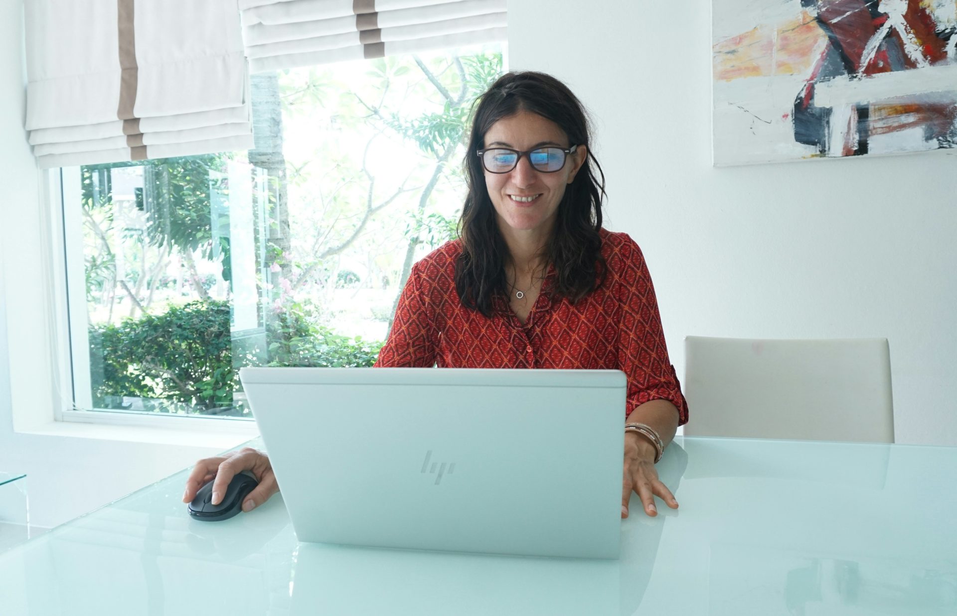 Woman smiles while working on a laptop.